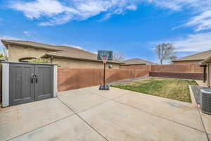 View of patio with cooling unit and a fenced backyard