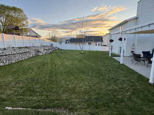 View of yard featuring fence and a patio area