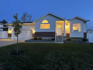 View of front of house with an attached garage, fence, a front yard, and concrete driveway