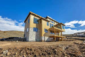 Rear view of property with stone siding