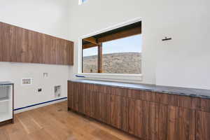 Laundry room featuring washer hookup, cabinet space, electric dryer hookup, and light wood-style flooring