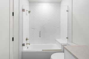 Full bath featuring combined bath / shower with glass door and vanity