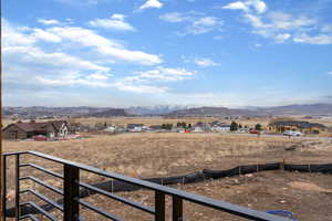 View of yard featuring a mountain view, a balcony, and a view of countryside