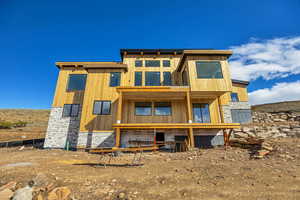 Back of house featuring stone siding