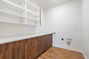 Laundry area featuring light wood-style flooring, washer hookup, and hookup for an electric dryer