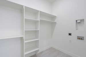 Laundry area with electric dryer hookup, light wood finished floors, and hookup for a washing machine