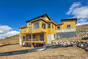 Back of house with stone siding