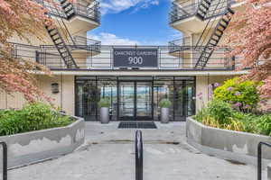 Doorway to property with brick siding and a balcony