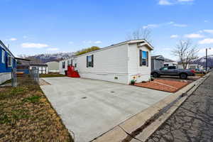 View of home's exterior featuring crawl space, a mountain view, driveway, and fence