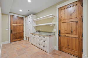 Interior space featuring visible vents, baseboards, light tile patterned floors, recessed lighting, and a sink