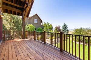 Wooden terrace featuring a yard