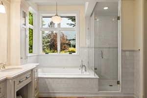 Full bath featuring a bath, a stall shower, and vanity