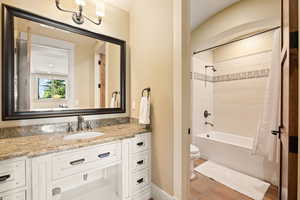 Bathroom featuring toilet, shower / tub combo, tile patterned flooring, baseboards, and vanity
