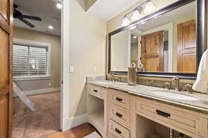 Bathroom featuring tile patterned flooring, double vanity, a ceiling fan, and a sink