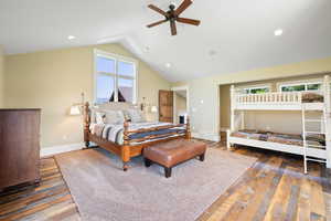 Bedroom featuring visible vents, lofted ceiling, baseboards, and wood-type flooring