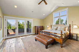 Bedroom with access to exterior, ceiling fan, baseboards, lofted ceiling, and wood-type flooring