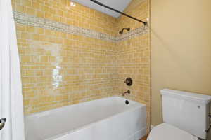Full bathroom with shower / bath combination with curtain and toilet