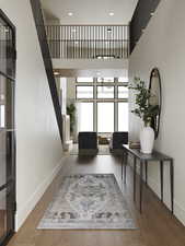Rendering of Entryway with a high ceiling, stairs, and wood finished floors