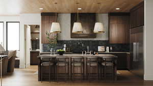 Rendering of Kitchen featuring high end refrigerator, a center island, light wood finished floors, recessed lighting, and tasteful backsplash