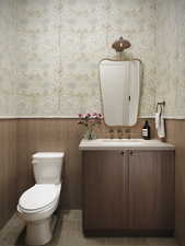 Rendering of Half bath with wainscoting, vanity, wallpapered walls, and tile patterned floors