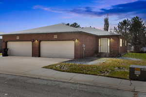 View of front facade featuring entry steps, concrete driveway, brick siding, and a garage