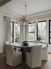 Dining space featuring a chandelier, a tray ceiling, wood finished floors, and recessed lighting