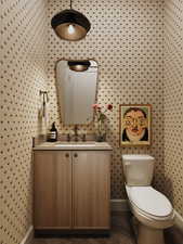 Bathroom with vanity and wallpapered walls