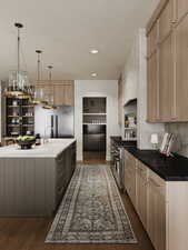 Kitchen featuring light brown cabinets, dark wood finished floors, a center island with sink, high quality appliances, and pendant lighting