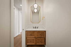 Bathroom with vanity, dark wood-style floors, and recessed lighting