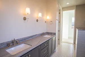 Bathroom featuring double vanity, walk in shower, and recessed lighting