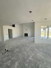 Unfurnished living room with a fireplace and a textured ceiling