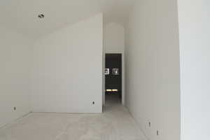 Unfurnished room with high vaulted ceiling
