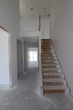 Staircase featuring unfinished concrete floors