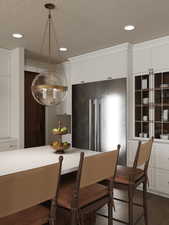 Rendering of Kitchen with high quality fridge, white cabinets, recessed lighting, a kitchen breakfast bar, and dark wood-type flooring