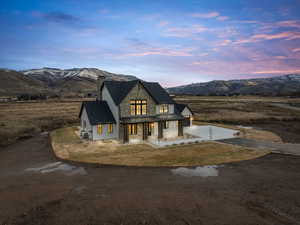 View of front facade with a standing seam roof, covered porch, a metal roof, driveway, and a mountain view