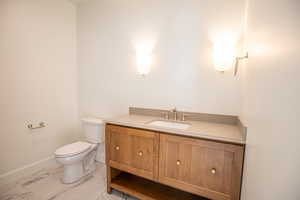 Bathroom with vanity and light marble finish flooring