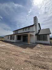 Rear view of property featuring a patio, board and batten siding, and a chimney