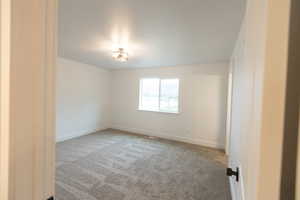 Carpeted empty room with baseboards