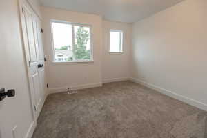 Carpeted empty room featuring visible vents and baseboards
