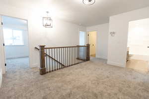 Carpeted spare room with baseboards and a chandelier