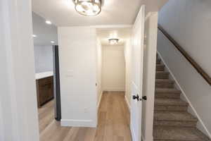 Stairway with recessed lighting, wood finished floors, and baseboards