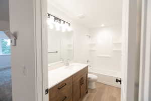 Bathroom with visible vents, toilet, wood finished floors, bathtub / shower combination, and vanity