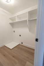 Laundry area with electric dryer hookup, wood finished floors, baseboards, hookup for a washing machine, and laundry area