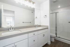 Full bath featuring a sink, wood finished floors, and a shower stall