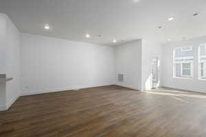 Empty room with recessed lighting, visible vents, baseboards, and wood finished floors