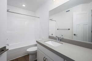 Full bath featuring vanity, wood finished floors, visible vents, shower / tub combination, and toilet