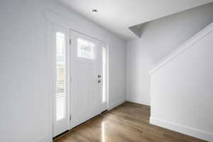 Entryway with baseboards and wood finished floors