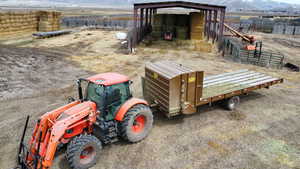 Exterior space featuring a rural view, fence, a mountain view, and an outbuilding