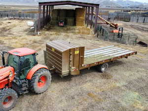Exterior space featuring a rural view, fence, a mountain view, and an outbuilding