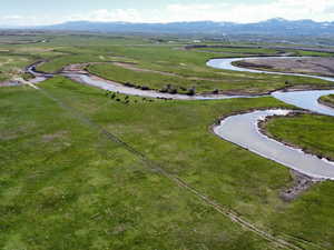 Aerial view of property and surrounding area with a mountainous background and rural landscape